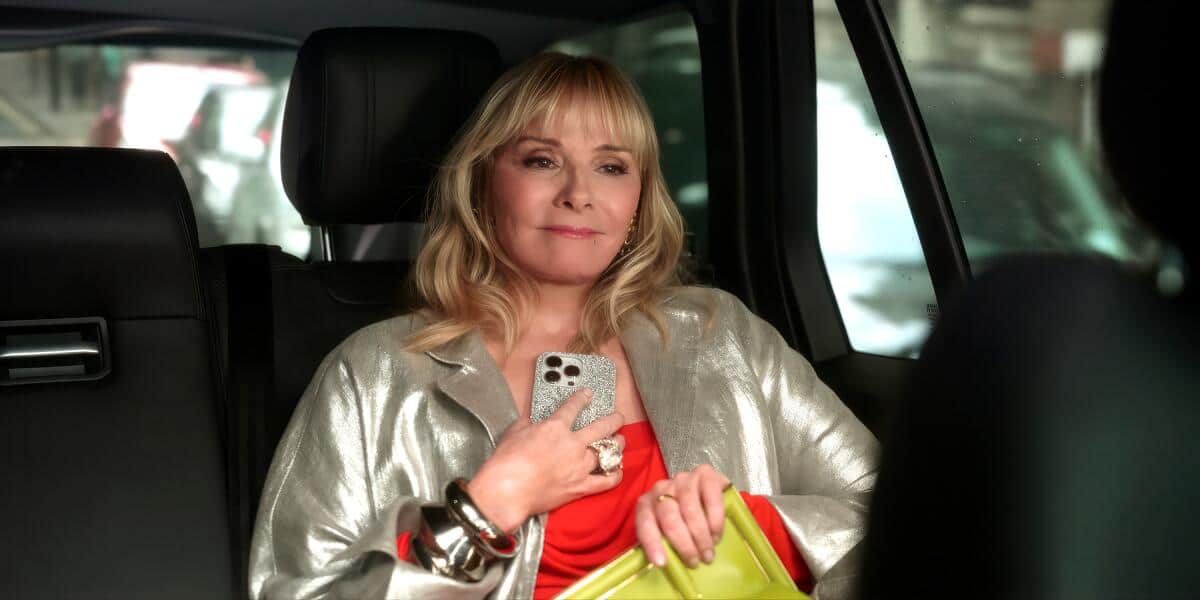 A woman sits in the back of a car holding a phone to her chest in this image from HBO Entertainment.
