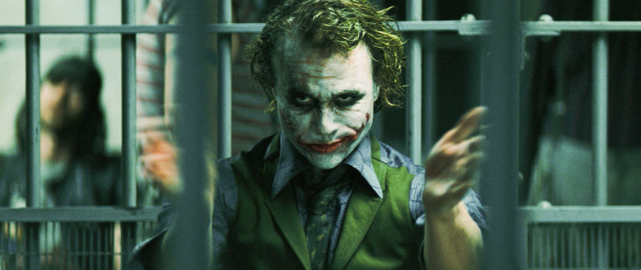 A man wearing face paint and clapping in this image from Warner Bros. Pictures.