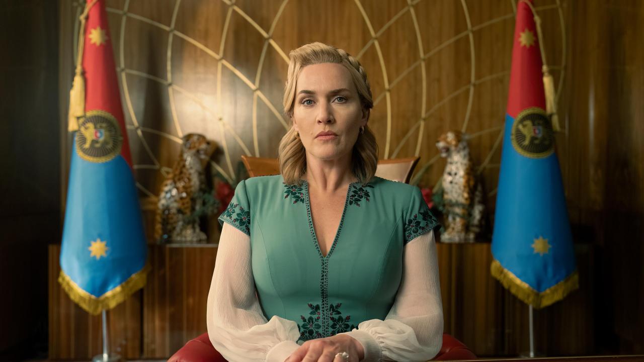 A woman sits in front of flags in this image from HBO Entertainment.