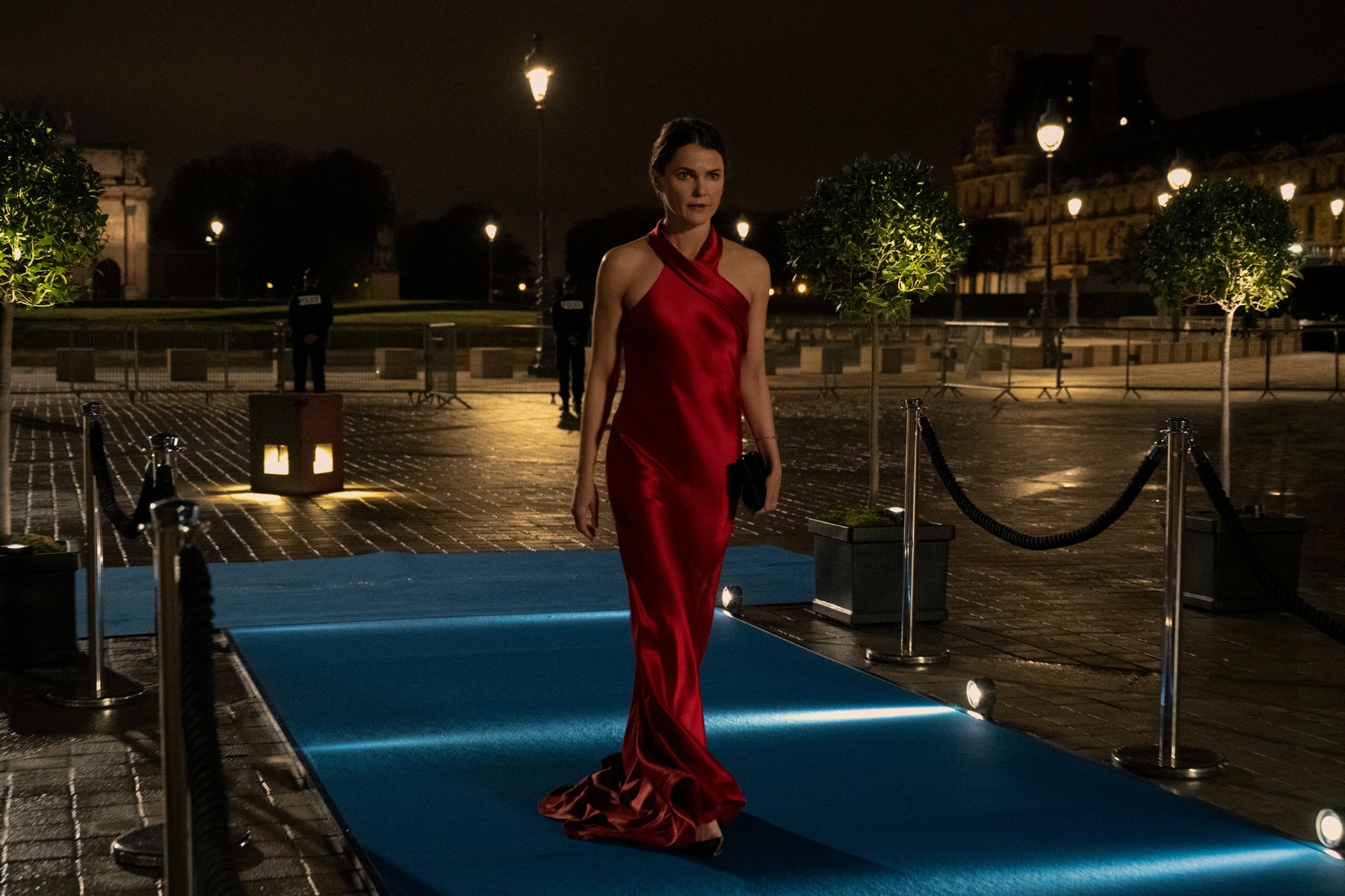 A woman in a gown enters an event in this image from Let's Not Turn This Into a Whole Big Production.