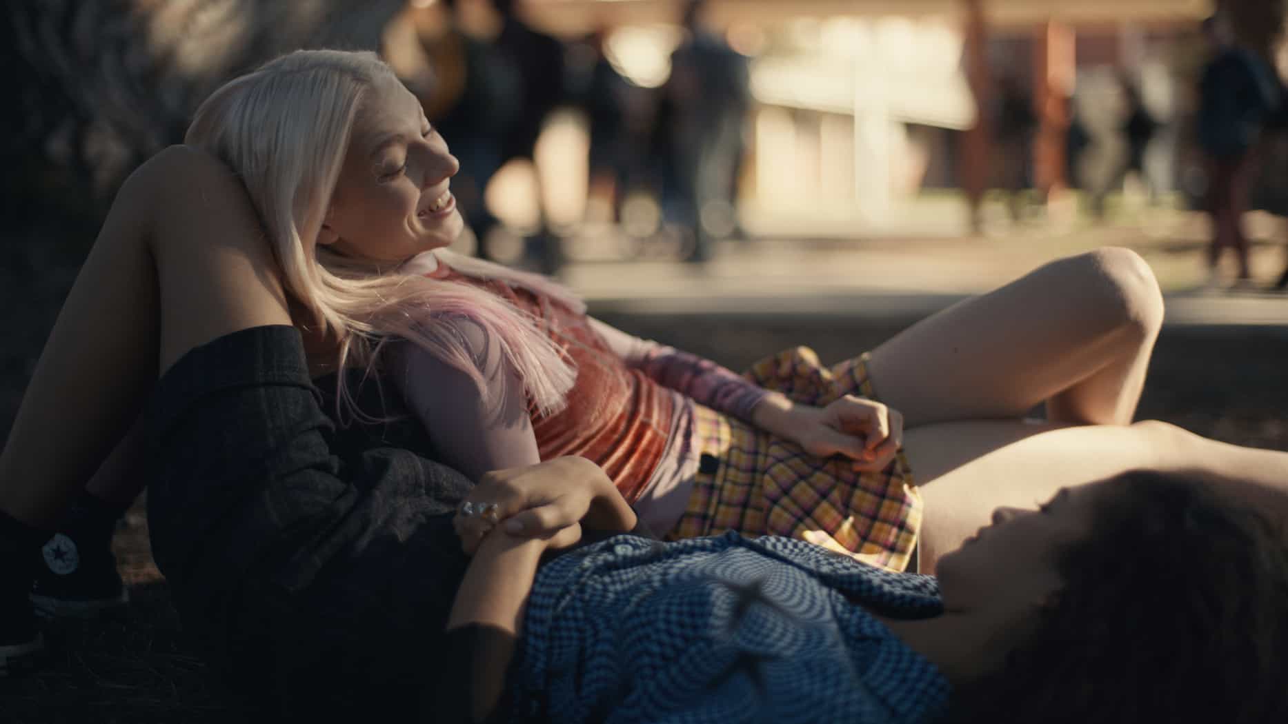 Two teens lay on the ground outside in this image from HBO Entertainment