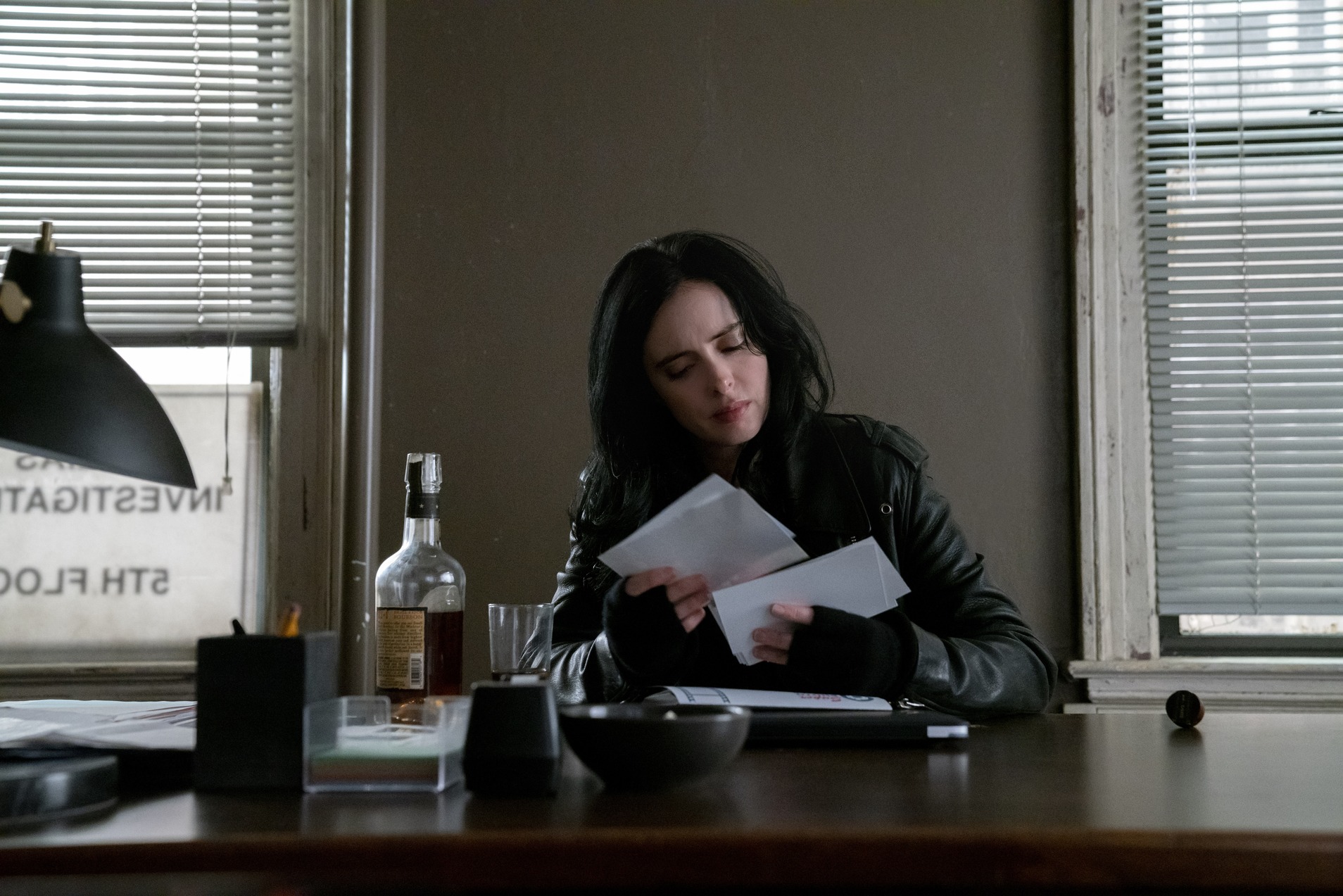 A woman looks through papers at a desk in this image from Marvel Television.