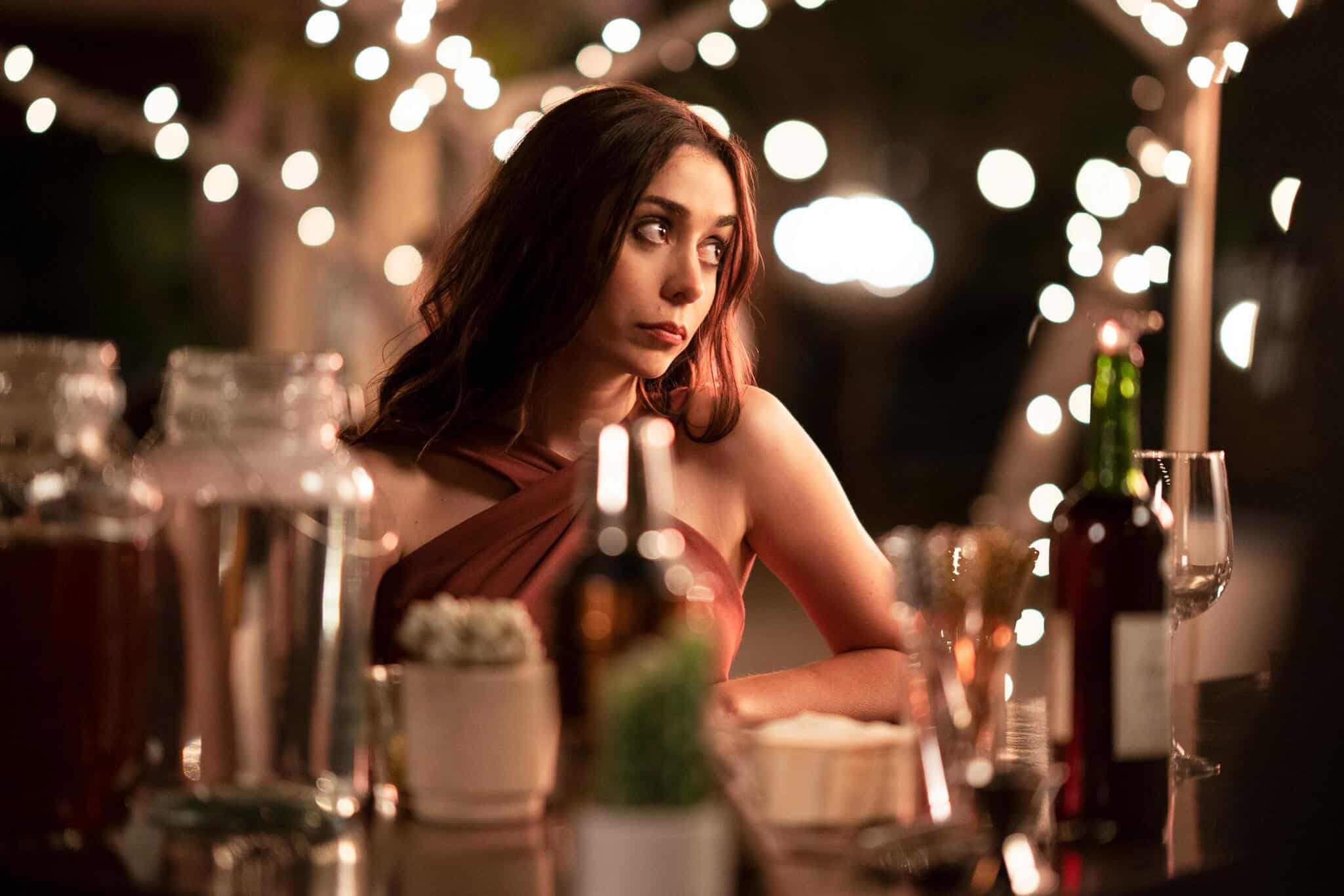 A woman stands near the bar at an outdoor party in this image from Limelight Productions.