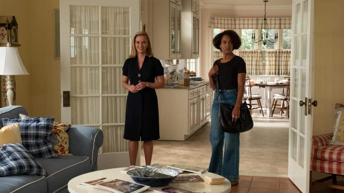 Two women stand around in a suburban living room in this image from ABC Signature