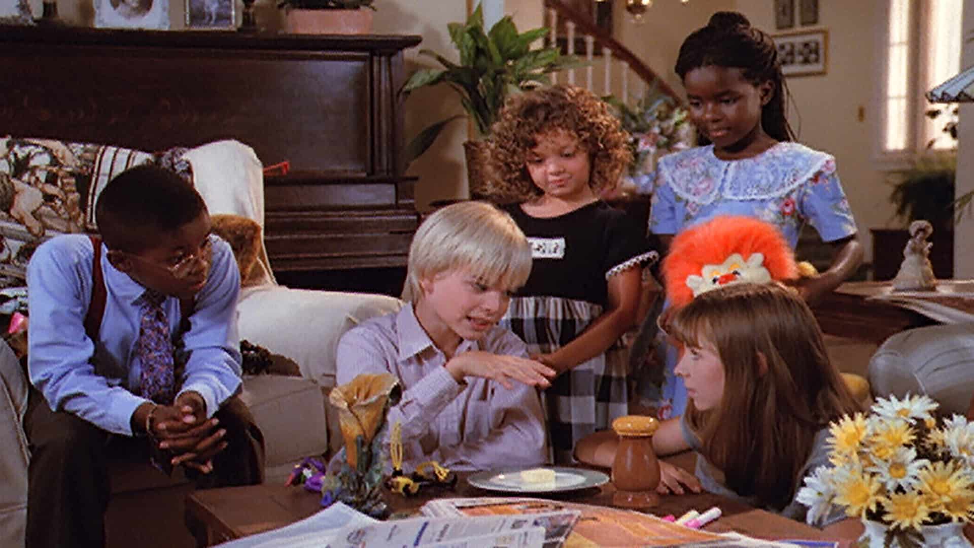 A group of children dressed for church gather around a coffee table in this photo from Spelling Television.