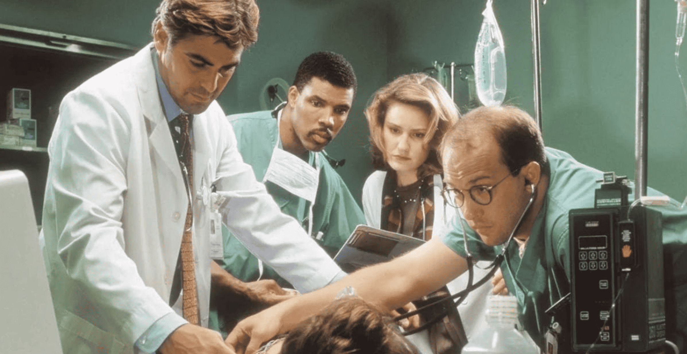 A group of doctors stand over a patient in this photo by John Wells Productions.