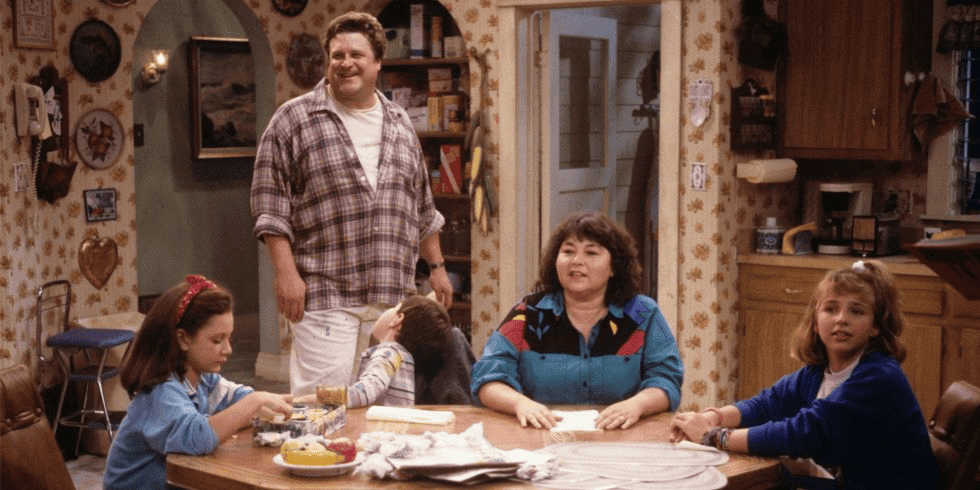 A family gathers around their kitchen table in this photo from The Carsey-Werner Company.