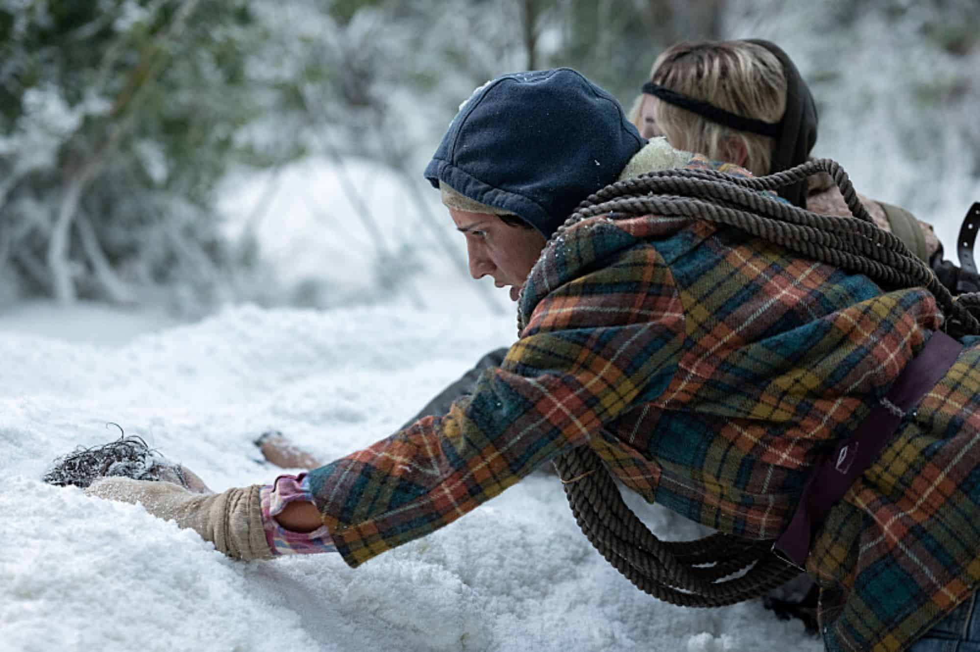 A man digs something up in the snow in this photo by Showtime.