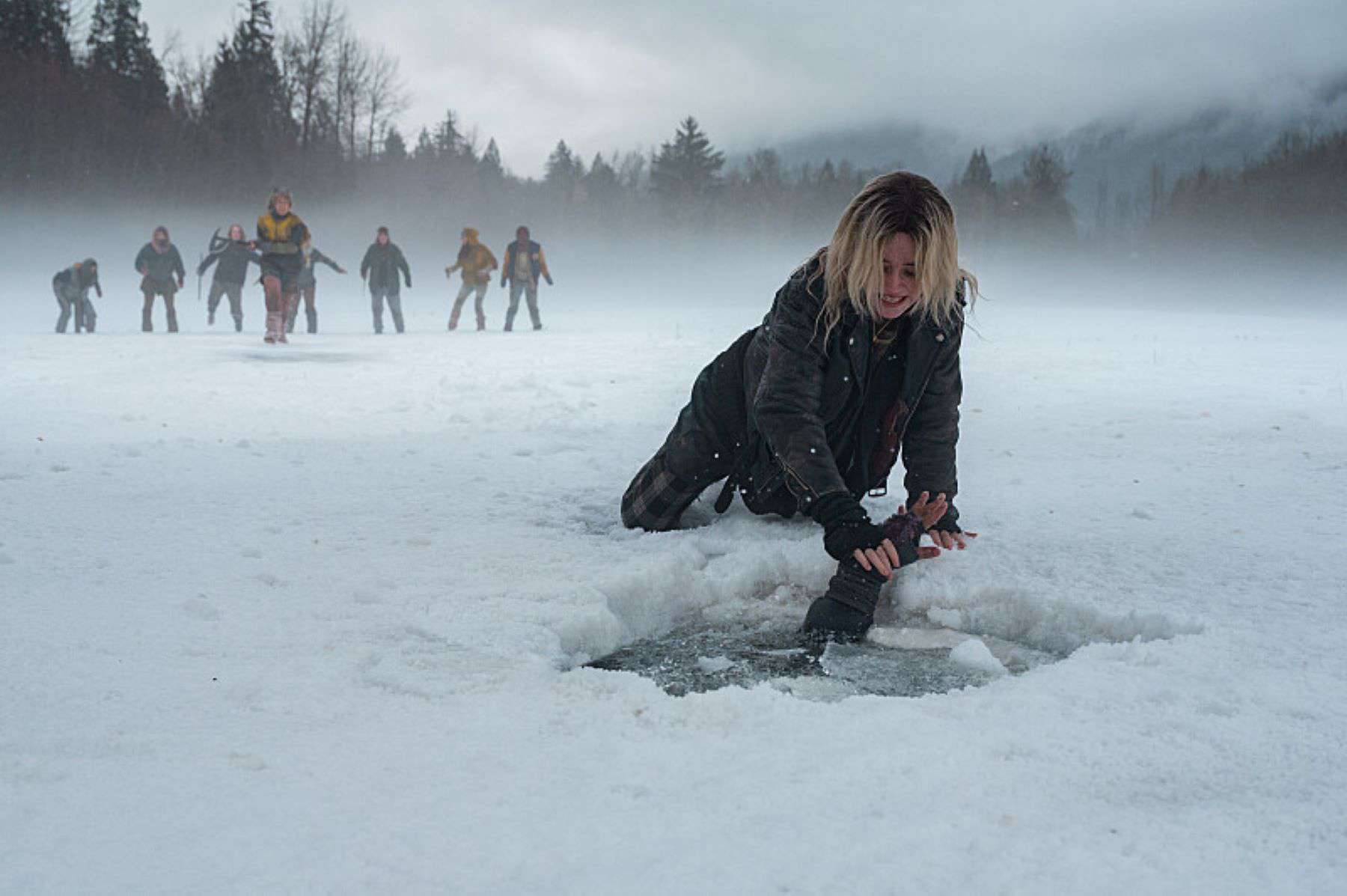 A girl attempts to pull someone out of the water in a frozen lake in this photo by Showtime.
