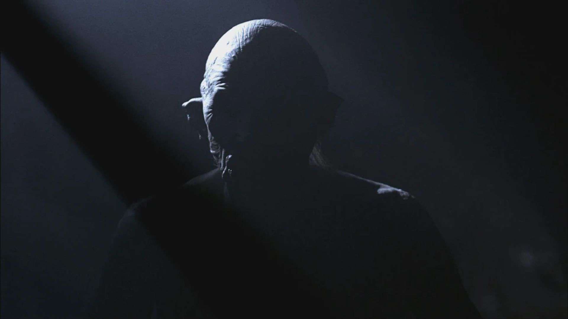 A wendigo hides in the shadows in this image from Warner Bros. Television.