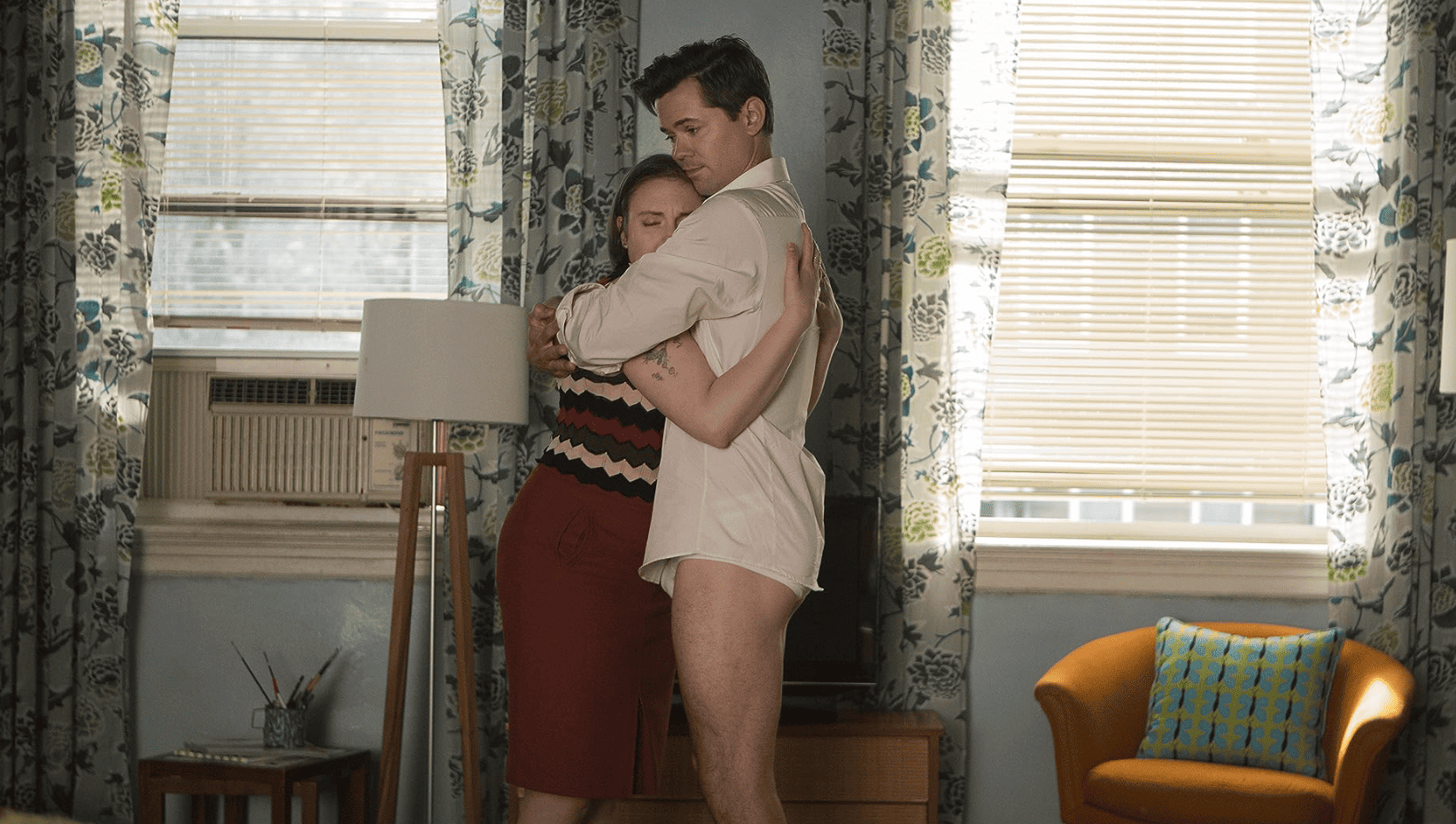A woman and a man hug in a living room in this image from Apatow Productions.