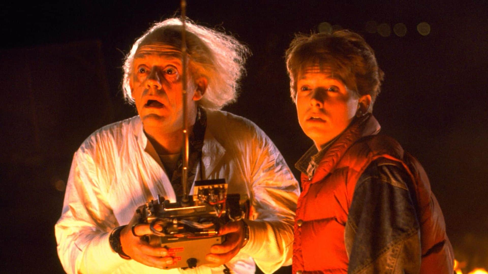 A white-haired man holding a remote control and a young man looking bewildered in this image from Amblin Pictures.