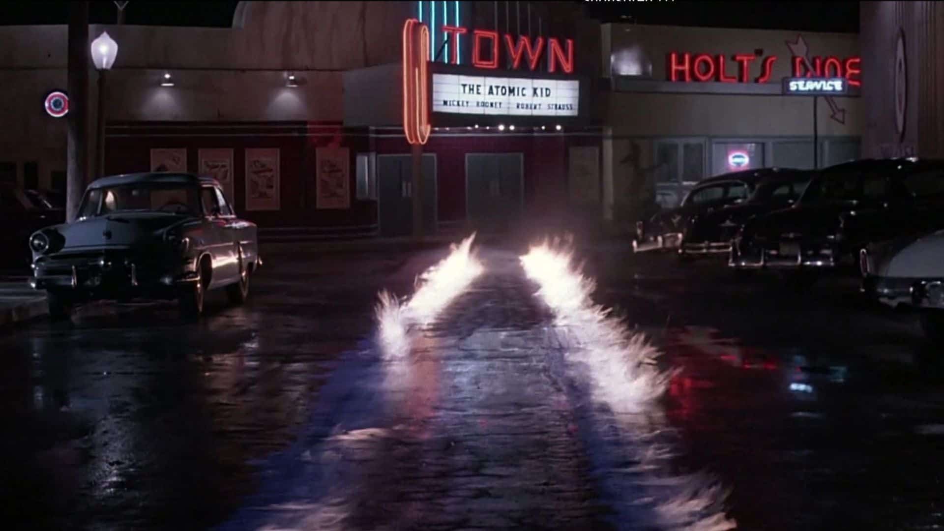 DeLorean tire marks on fire in front of a midcentury theater in this image from Amblin Pictures.