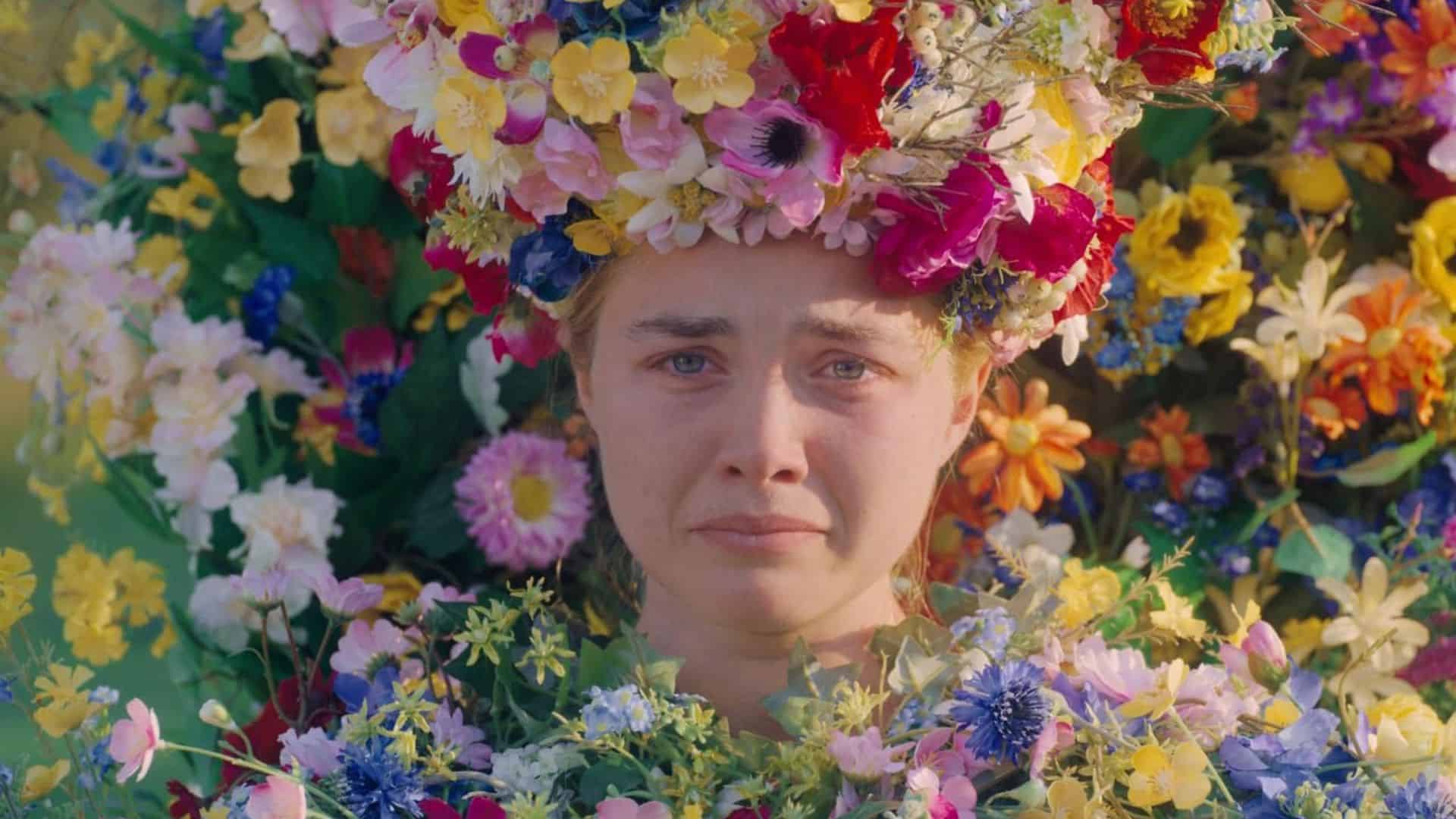 A young woman frowns wearing flowers in this image from A24.