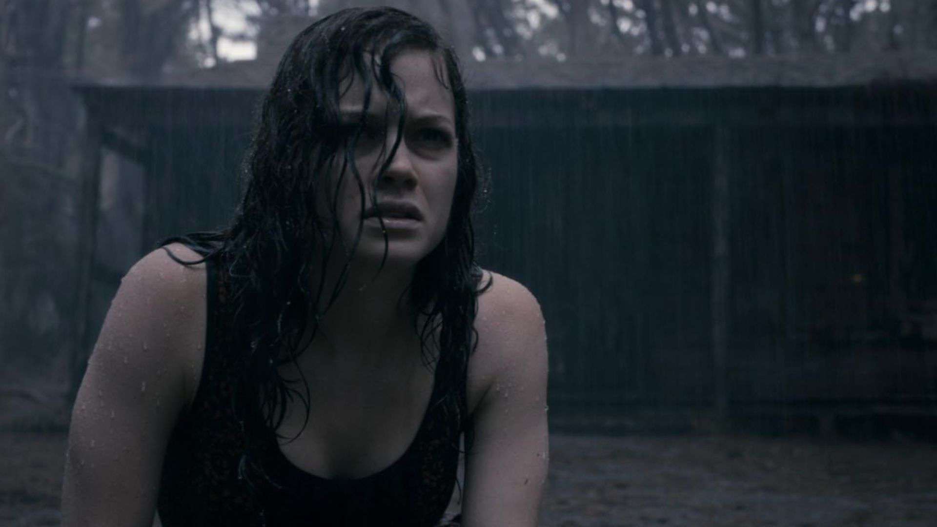 A woman sits outside in the rain in this image from Ghost House Pictures.