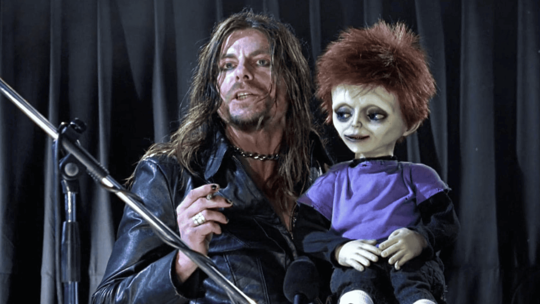 Keith-Lee Castle as “Psychs” holding a green, wide-eyed doll in this image from Rogue Pictures.