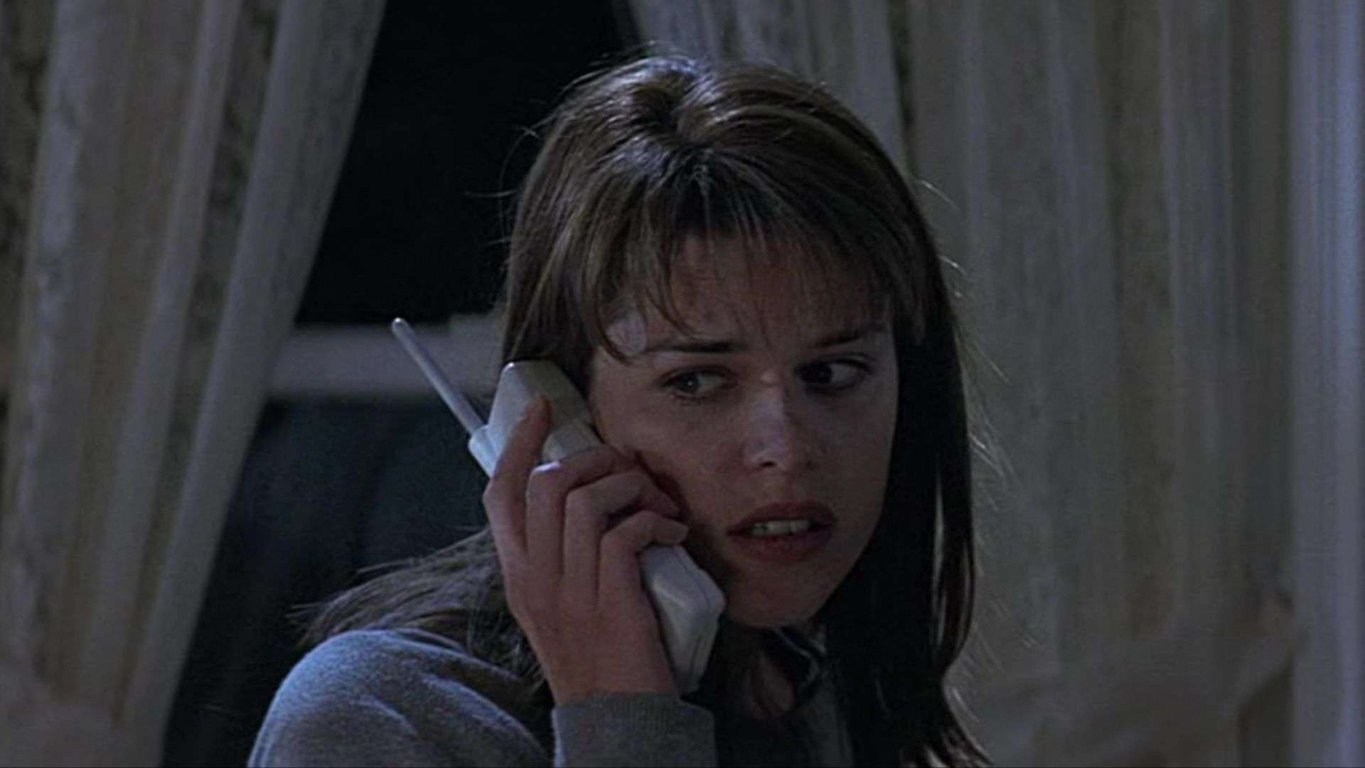 A woman looks over her shoulder on the phone in this image from Woods Entertainment.