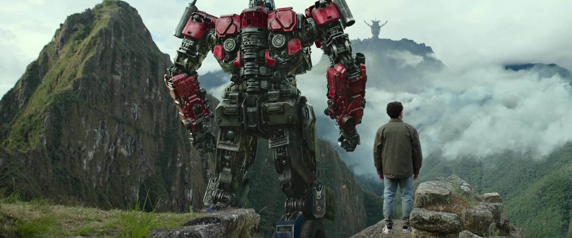 A Transformer and a man look down at clouds from a mountaintop in this photo from Di Bonaventura Pictures.