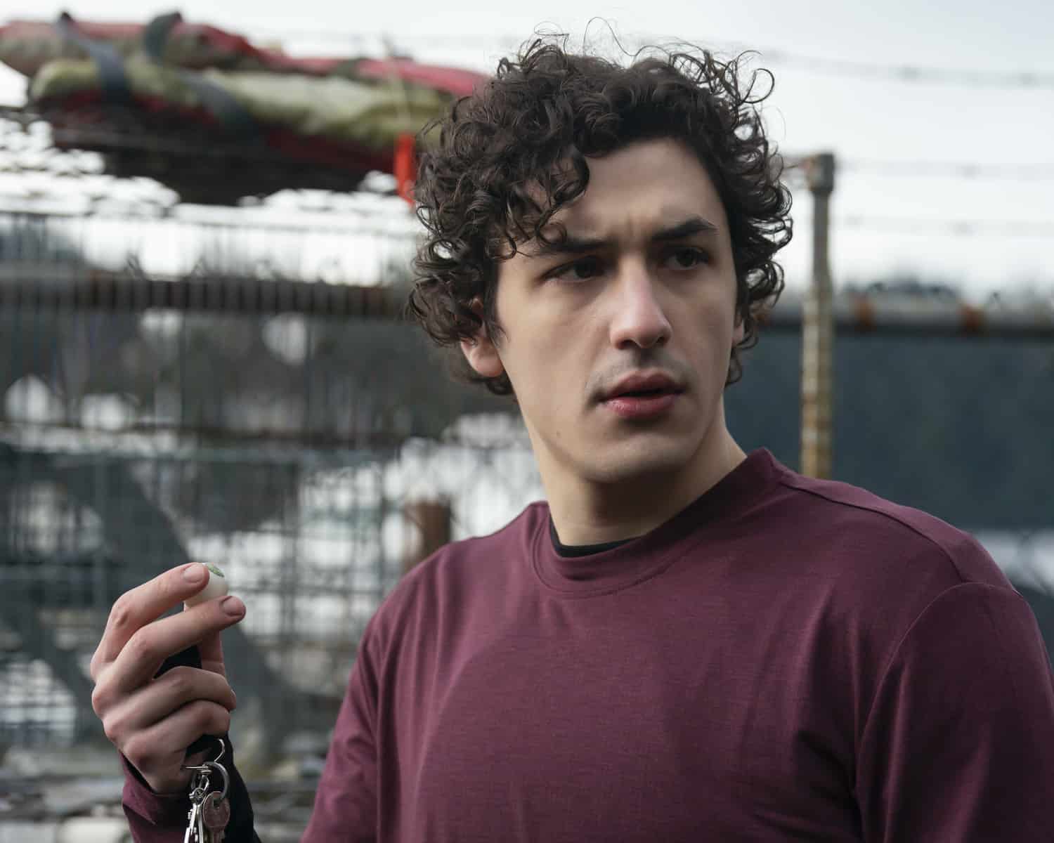 A teen boy holds an eyeball in front of an amusement-park ride in this photo from Sony Pictures Television.