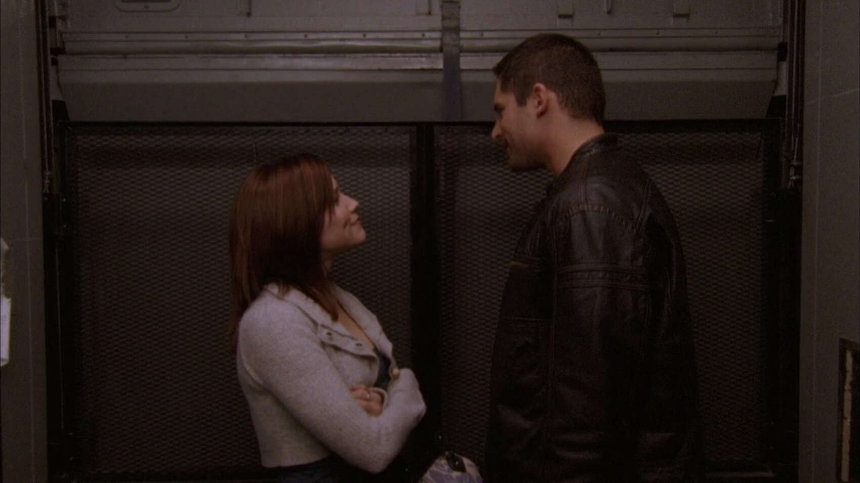A couple stands close together in an elevator in this image from Tollin/Robbins Productions.