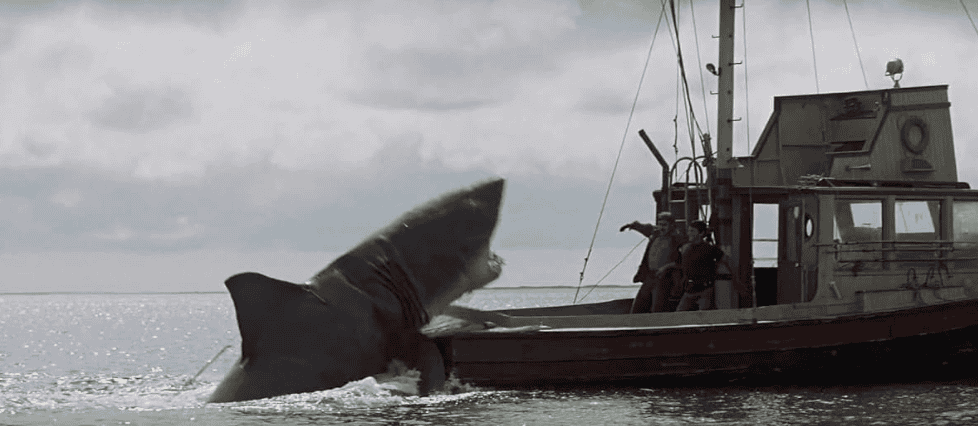 A giant shark attacks men on a boat in this image from Universal Pictures.