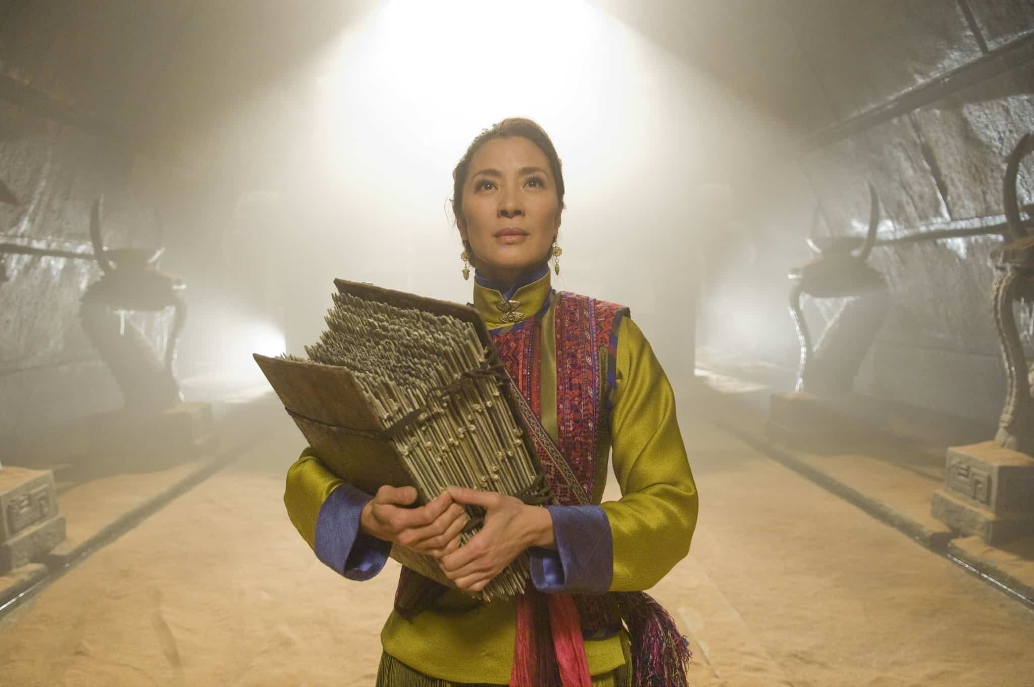 A woman carries a stack of old books in this image from Universal Pictures.