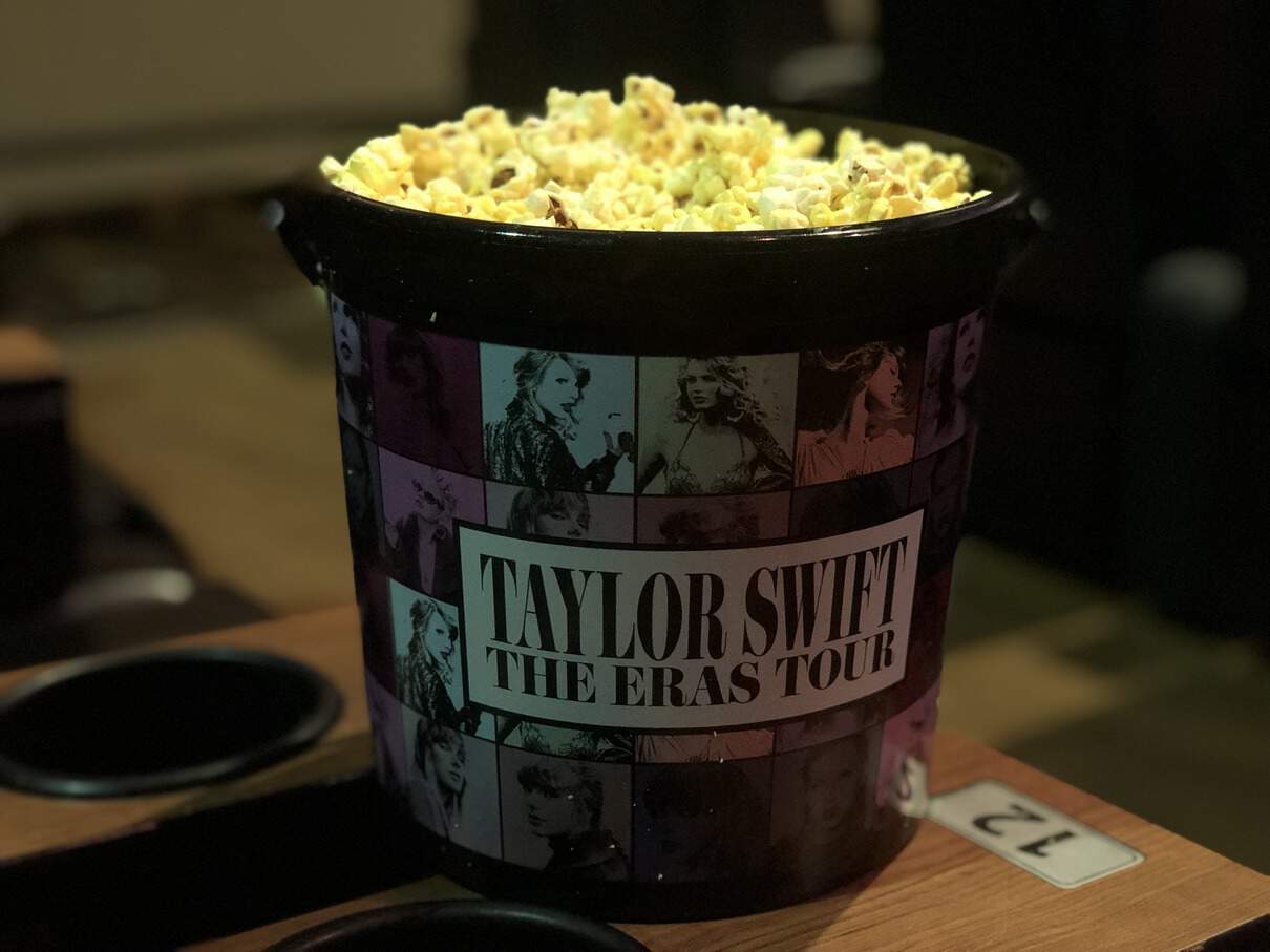 An Eras Tour popcorn bucket in a screening room in this image taken by the author. 