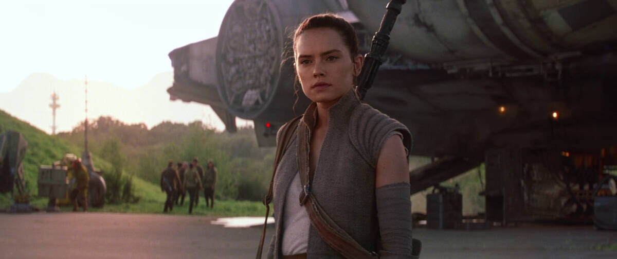 A young woman standing outside in front of a spaceship in this photo from Lucasfilm.