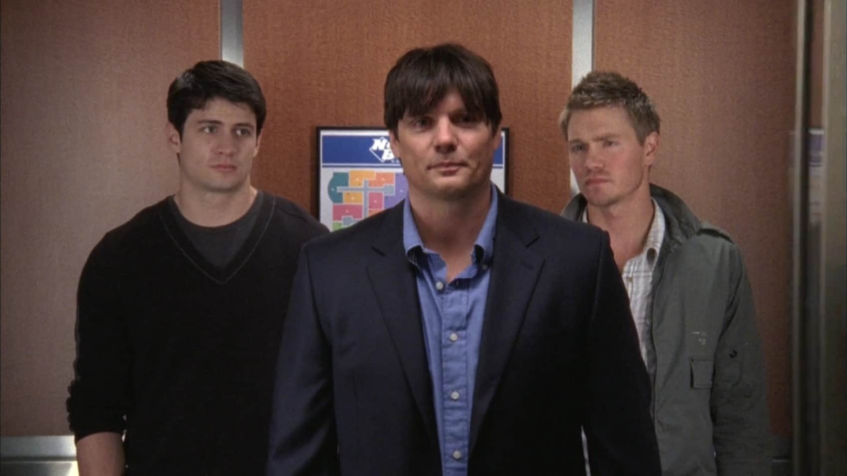 Three men stand in an elevator in this image from Tollin/Robbins Productions.