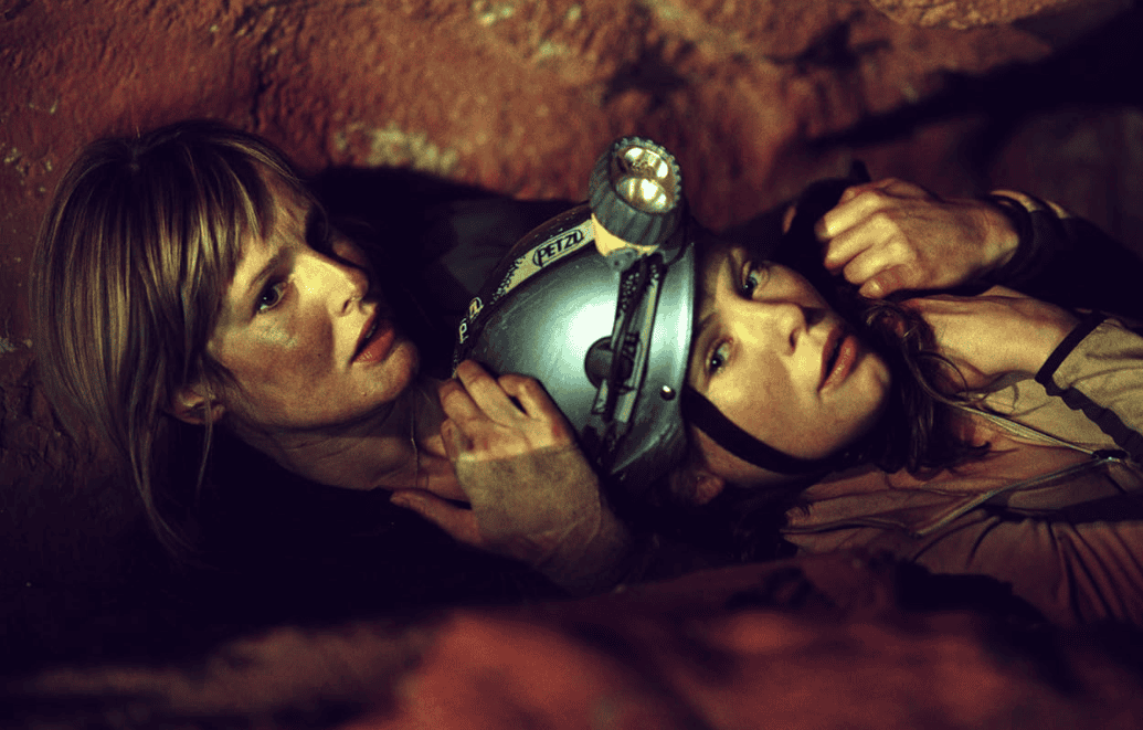 Two women lying in a cave in this image from Celador Films.