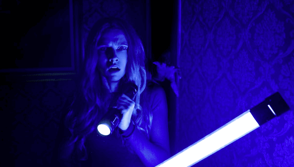 A woman holds a flashlight in this image from New Line Cinema.