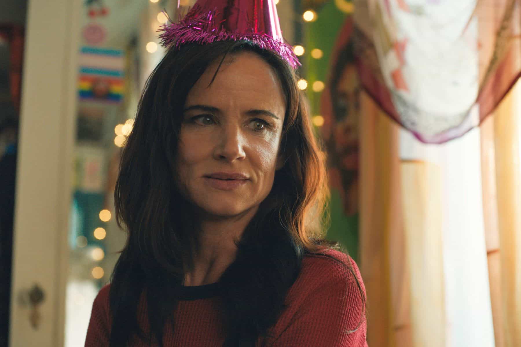 A woman in a party hat stares at something off-screen in this image from Universal Content Productions.