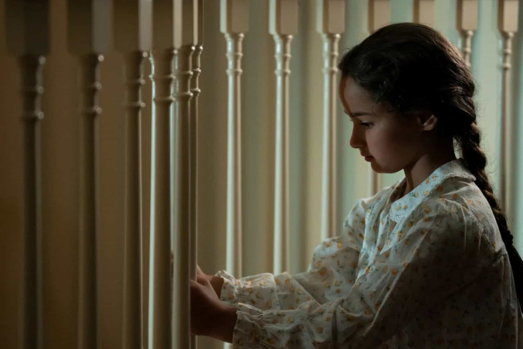 A young girl sits beside a staircase in this photo by Showtime.