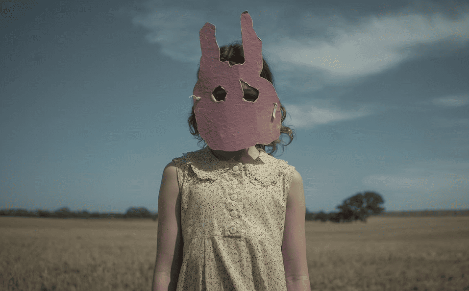  A young girl wears a pink rabbit mask in this image from Carver Films.