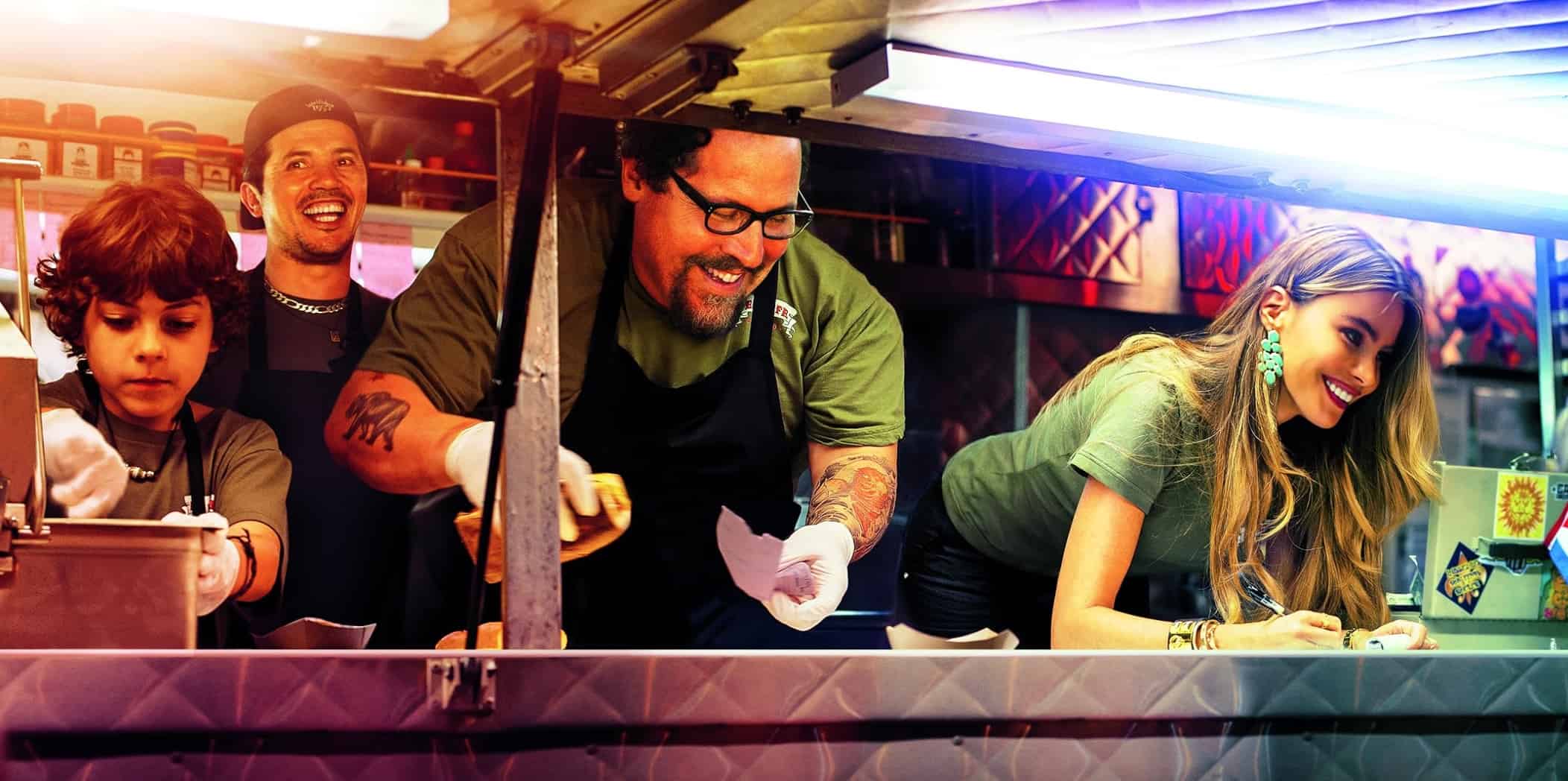 Two men, a boy, and a woman prepare sandwiches in a food truck in this image from Aldamisa Entertainment.
