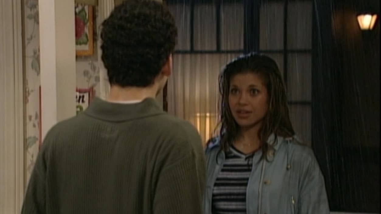 A teenage girl stands in an open doorway in the rain in front of a teenage boy in this image from Touchstone Pictures.