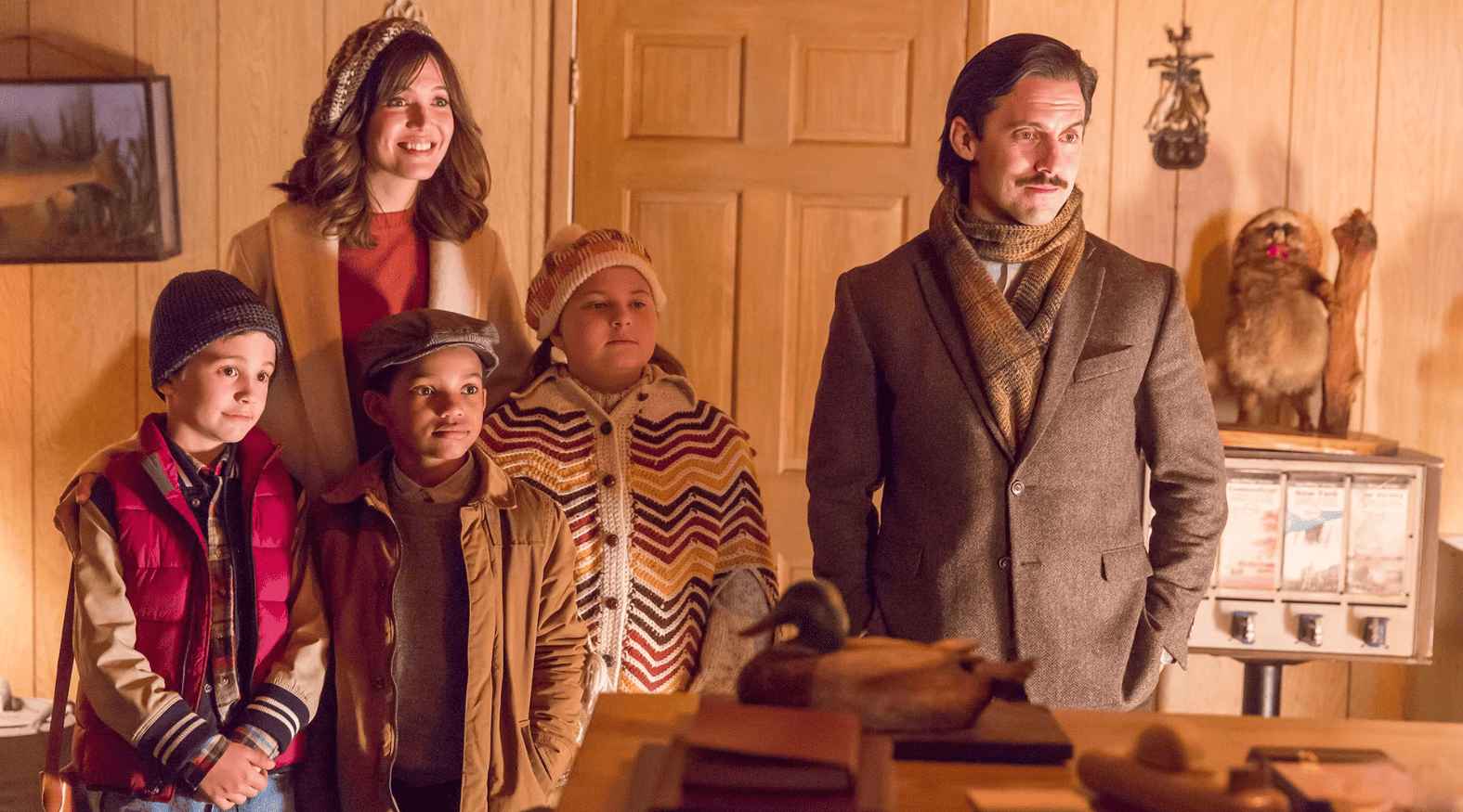 A family of five dressed for Thanksgiving stands in front of a hotel desk in this image from Rhode Island Ave. Productions.