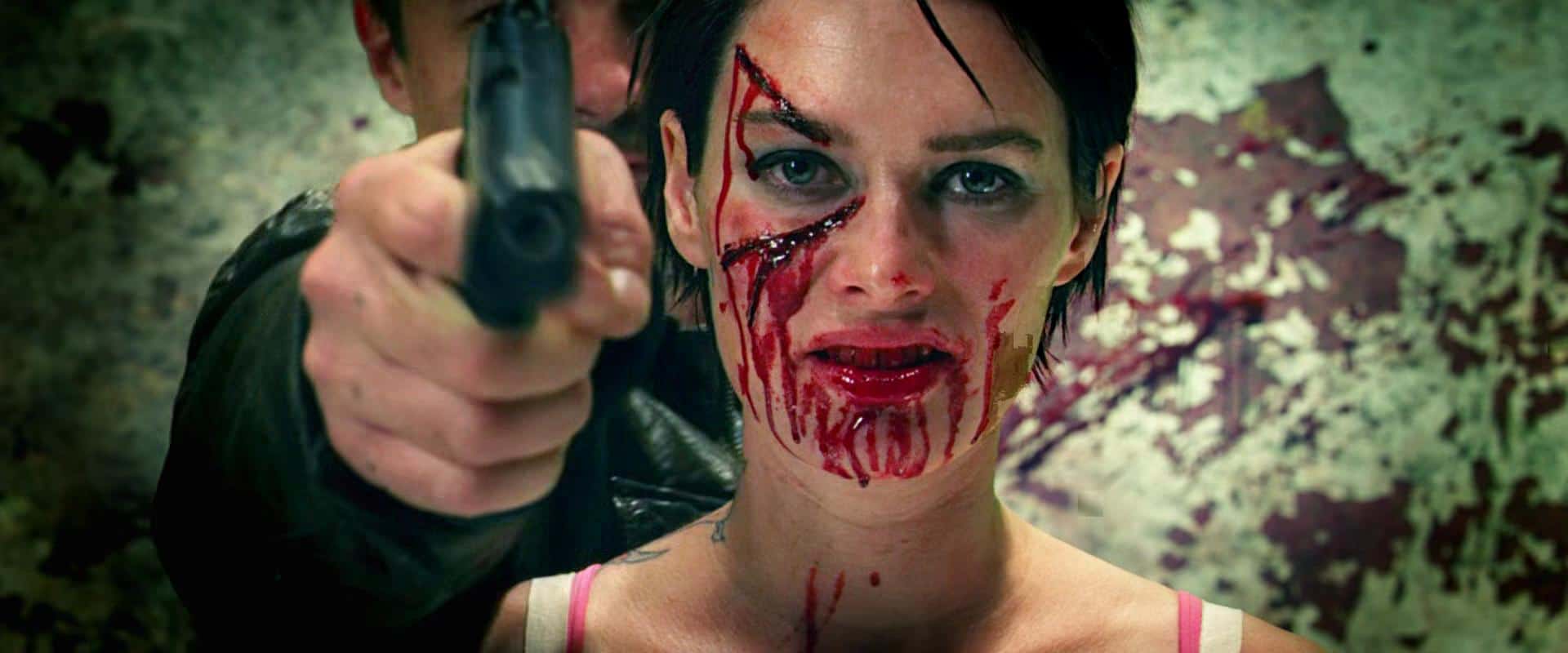 A man pointing a gun from behind a slash-covered Lena Headey in this image from DNA Films.