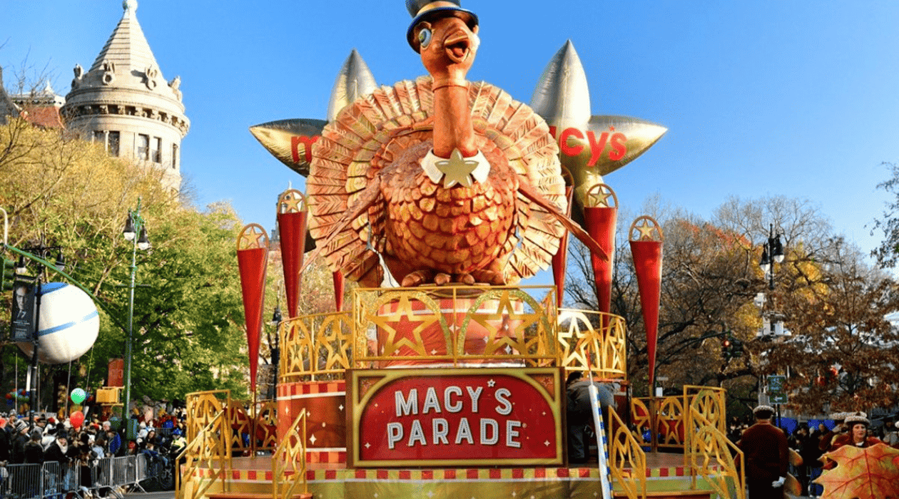 A large turkey balloon float makes its way down a busy parade route in this image from Macy’s NBC Brad Lachman Productions.