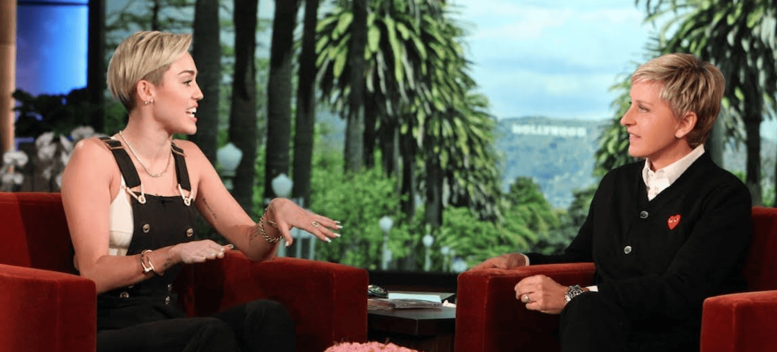 Two women talking to each other while sitting on the show’s red couches in this image from Time Telepictures Television.