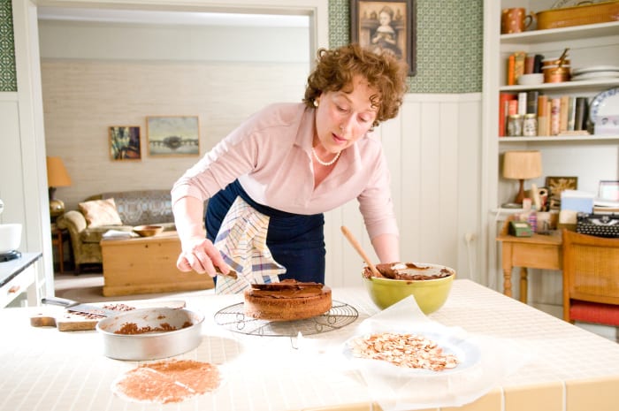 A woman leans over a table covered in baked goods in this image from Columbia Pictures.
