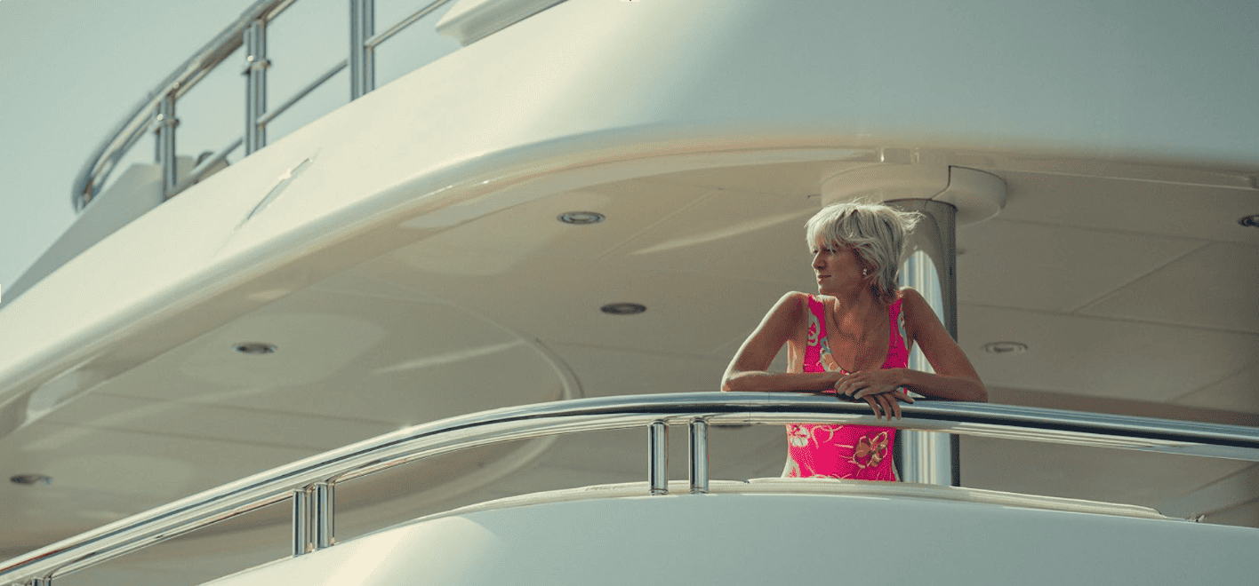 A woman leaning over a yacht and looking out into the ocean in this image from Sony Pictures Television.