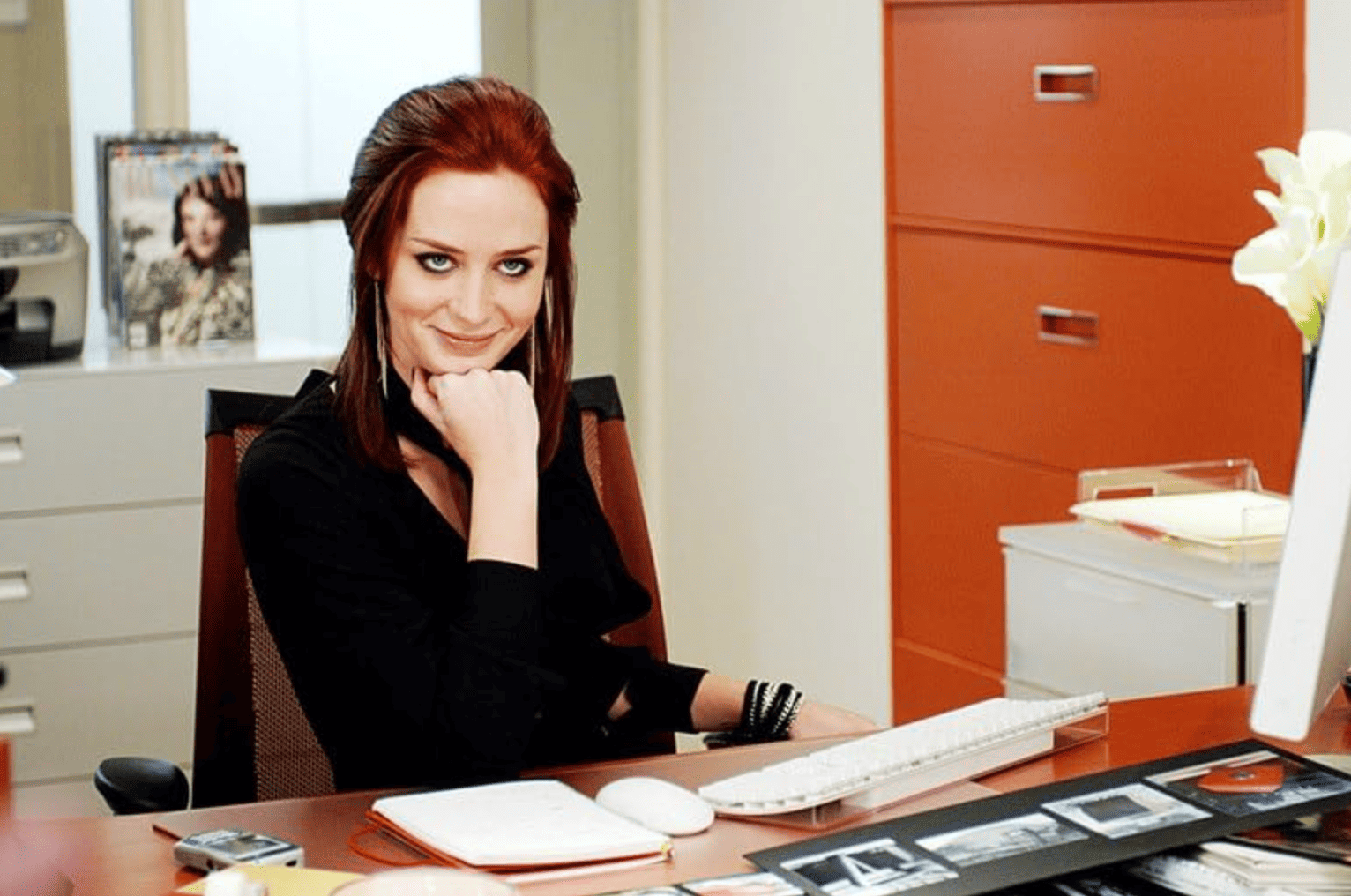 A woman smiles deviously from her desk in this image from Fox 2000 Pictures.