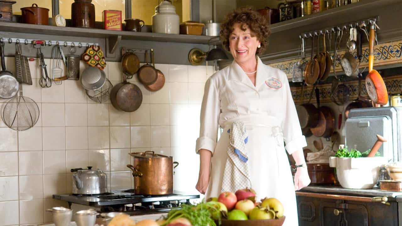 A woman stands in a kitchen surrounded by food in this image from Columbia Pictures.