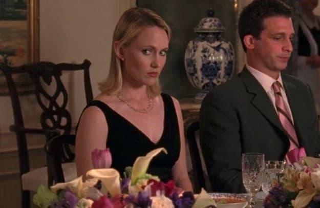 A woman side-eyes her off-screen mother at the dinner table in this image from Warner Bros. Television.