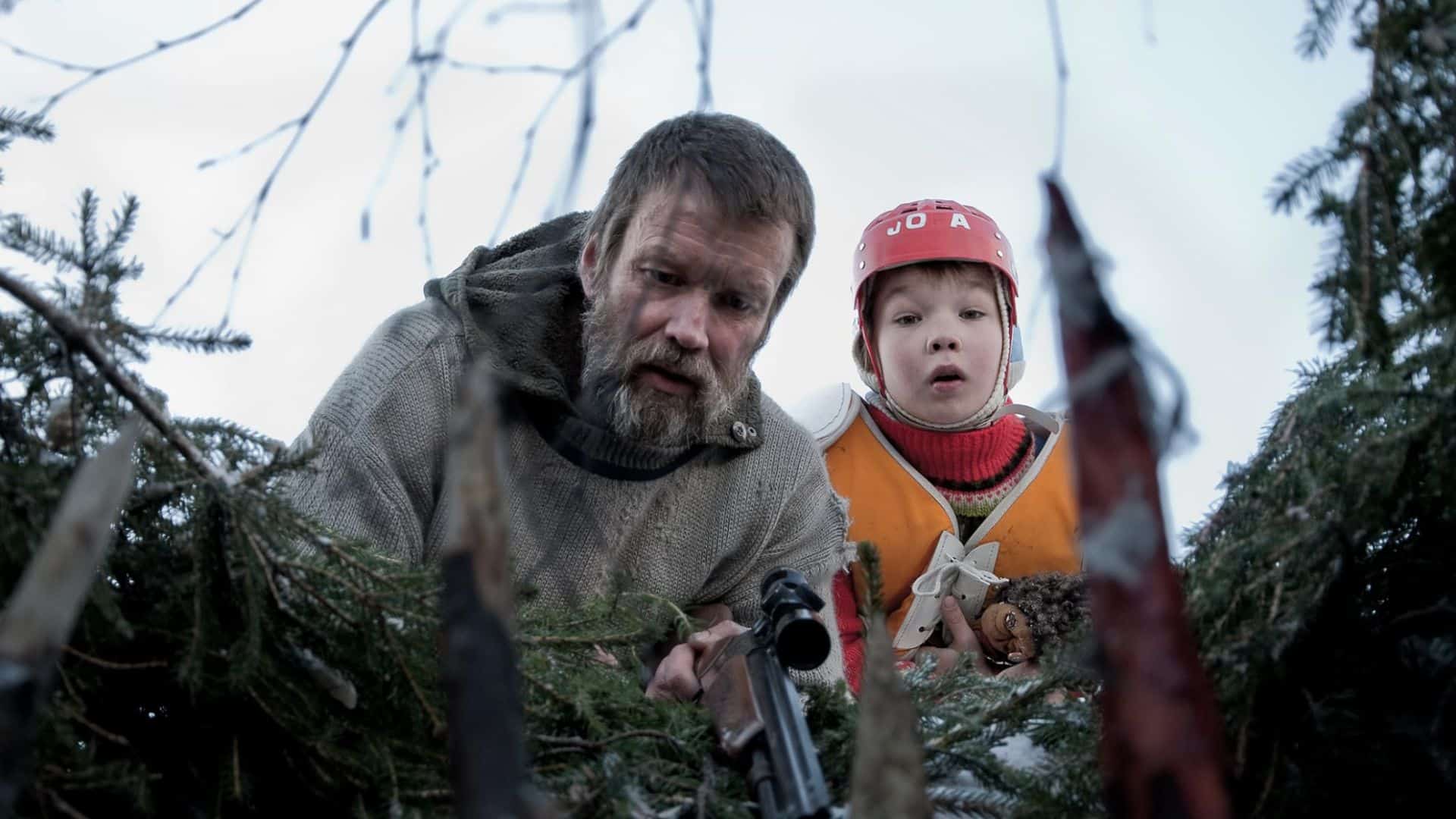 A man and a boy look into a trap with spikes in this image from Cinet.