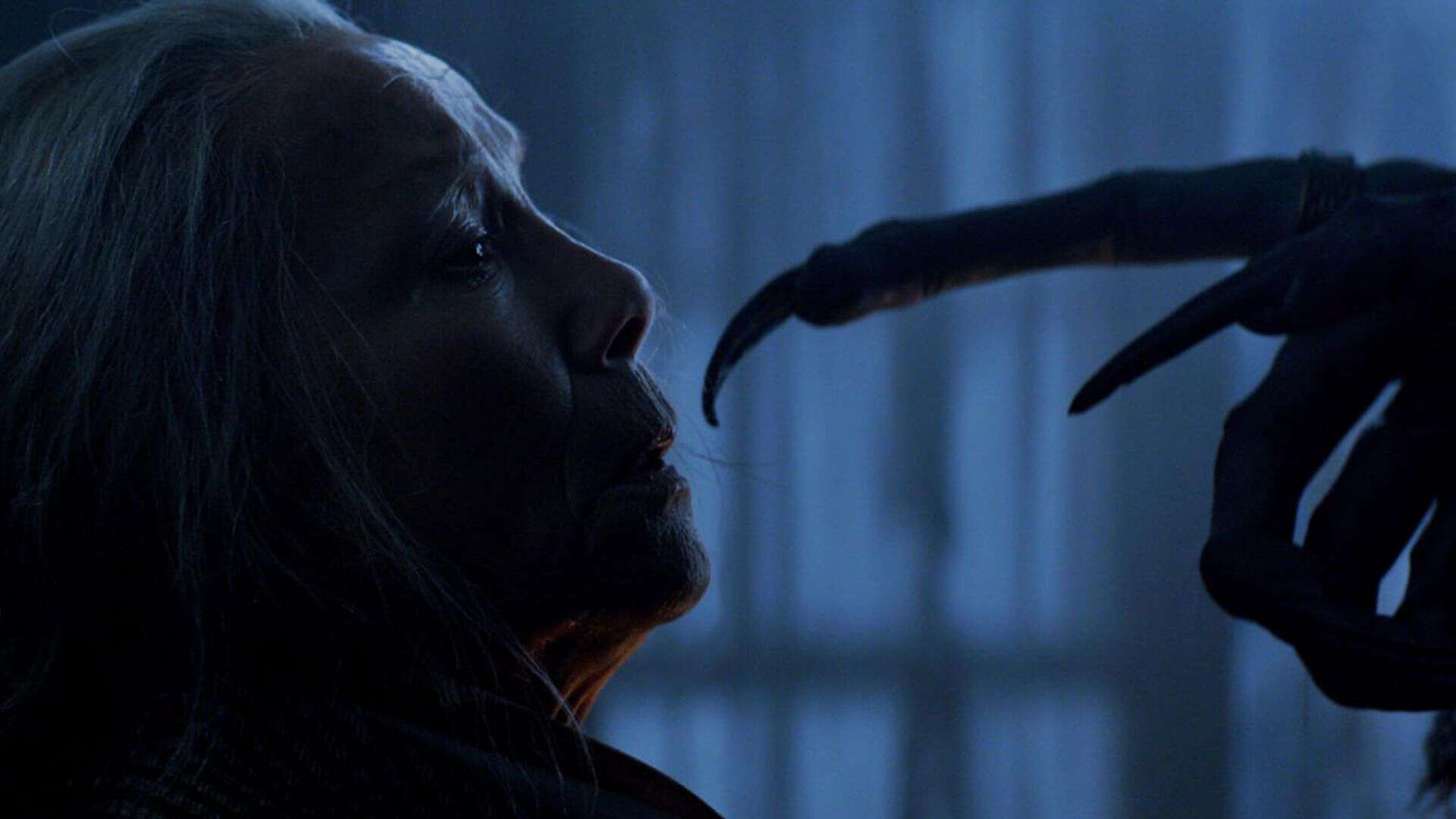 Krampus reaches for an old woman's face in this image from Legendary Pictures.