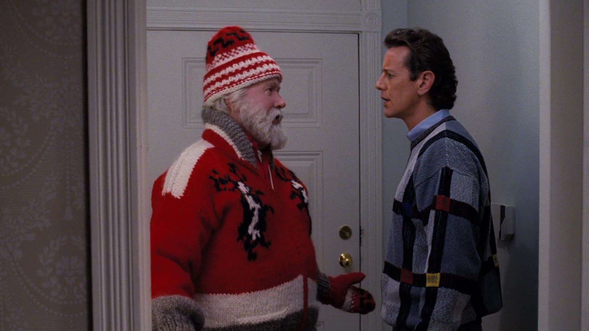 A man as Santa talks to another man in this image from Walt Disney Pictures.