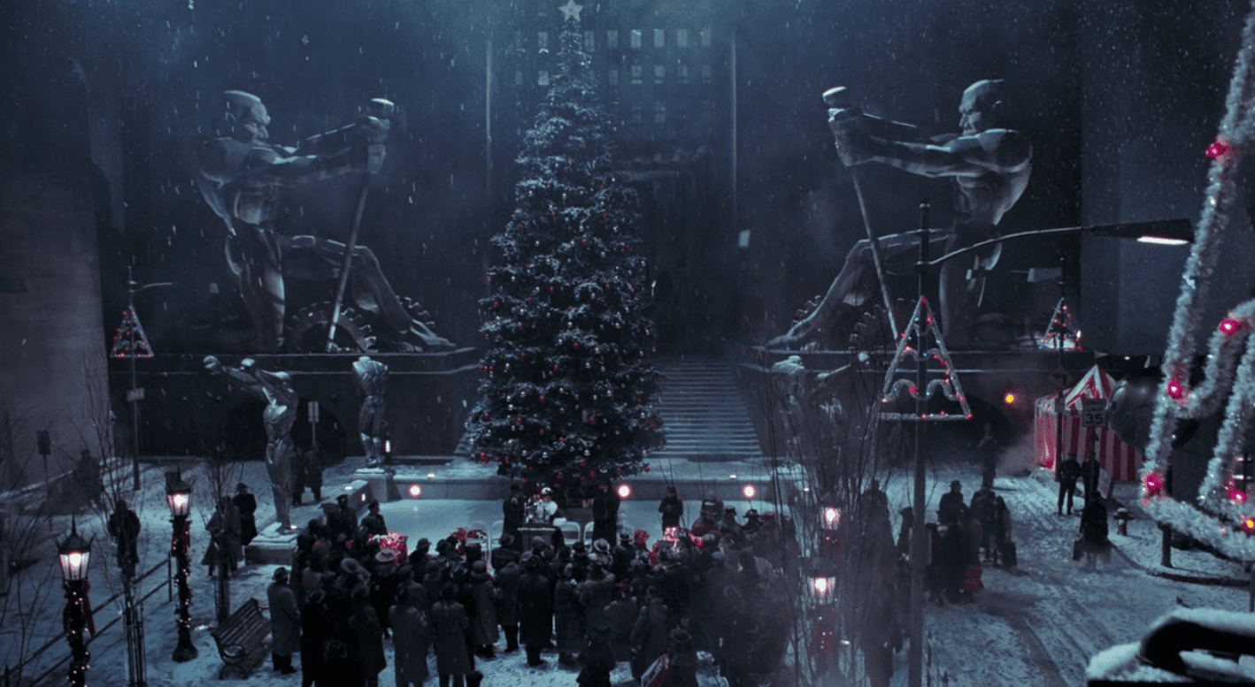 A dark city scene features a Christmas tree and crowd gathered in this image from Warner Bros.