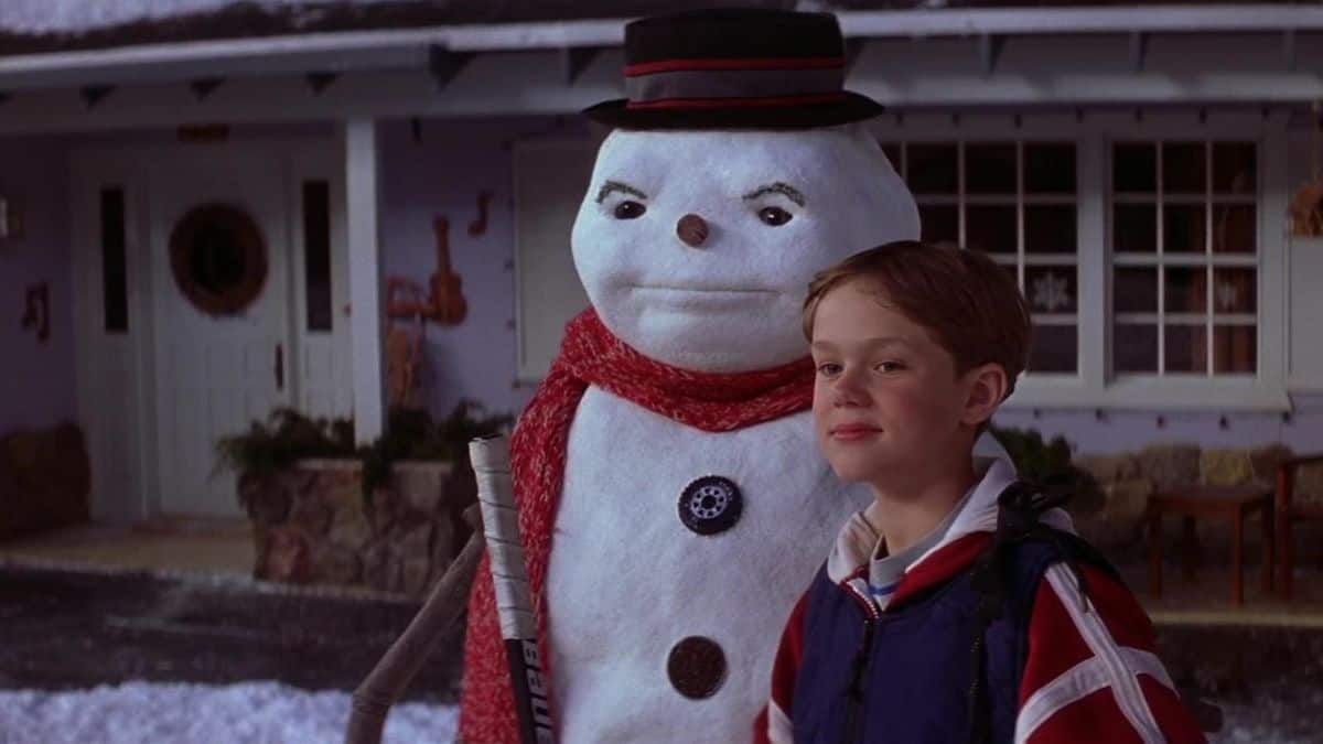 A young boy stands next to a living snowman in this image from Azoff Entertainment.